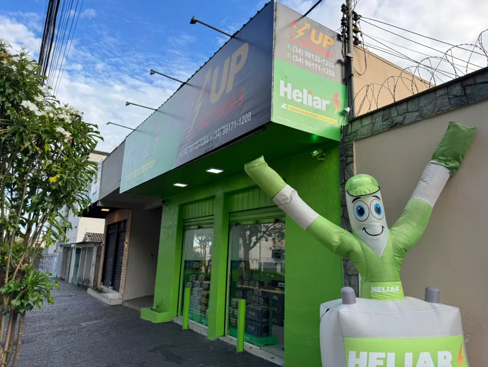 Vista lateral da loja UP Baterias com mascote Heliar